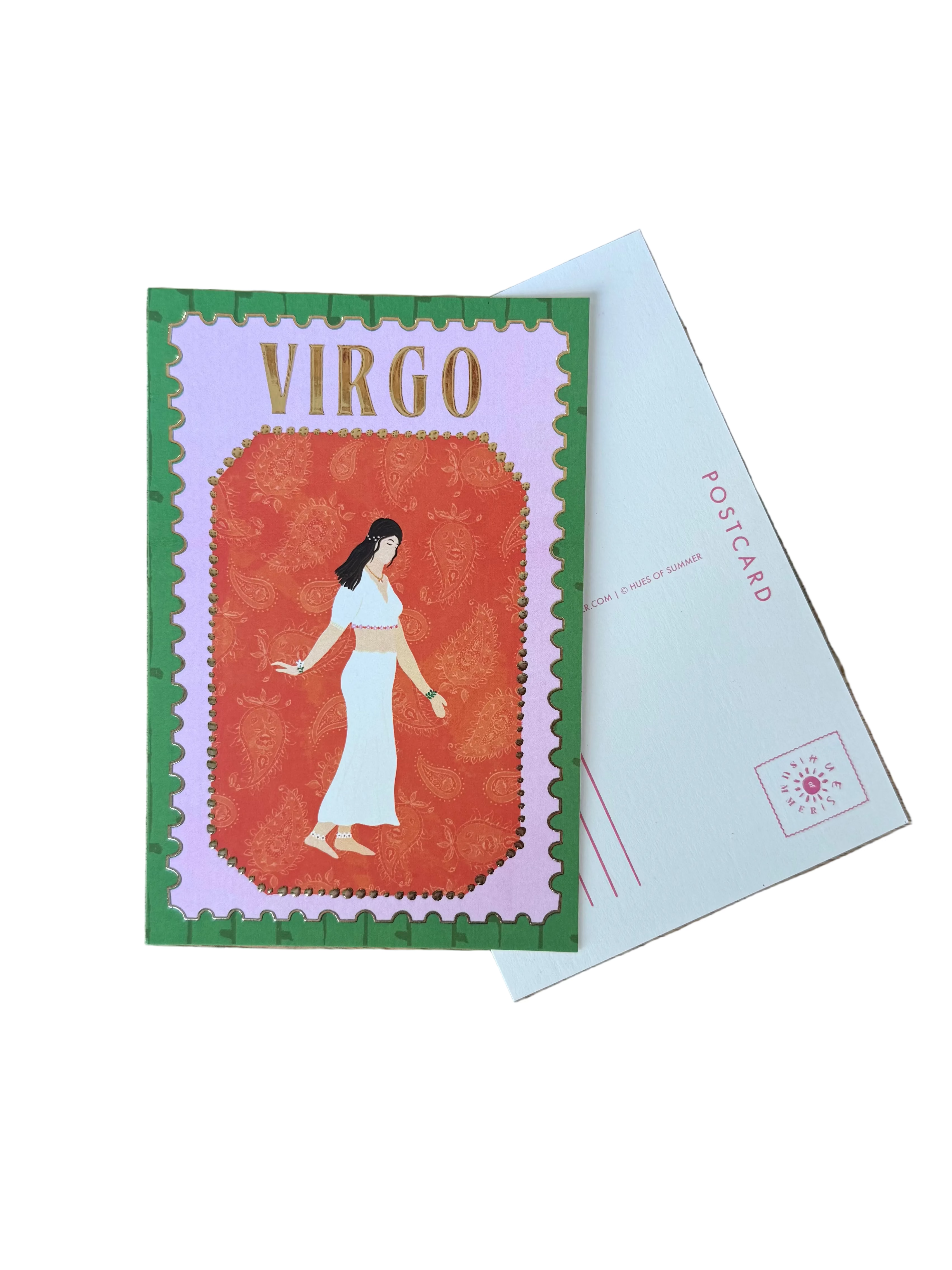 A vintage-style Virgo postage stamp card featuring an illustration of a woman in a white dress on an orange-red background, bordered in green and pink, placed on top of a white postcard on a wooden table.