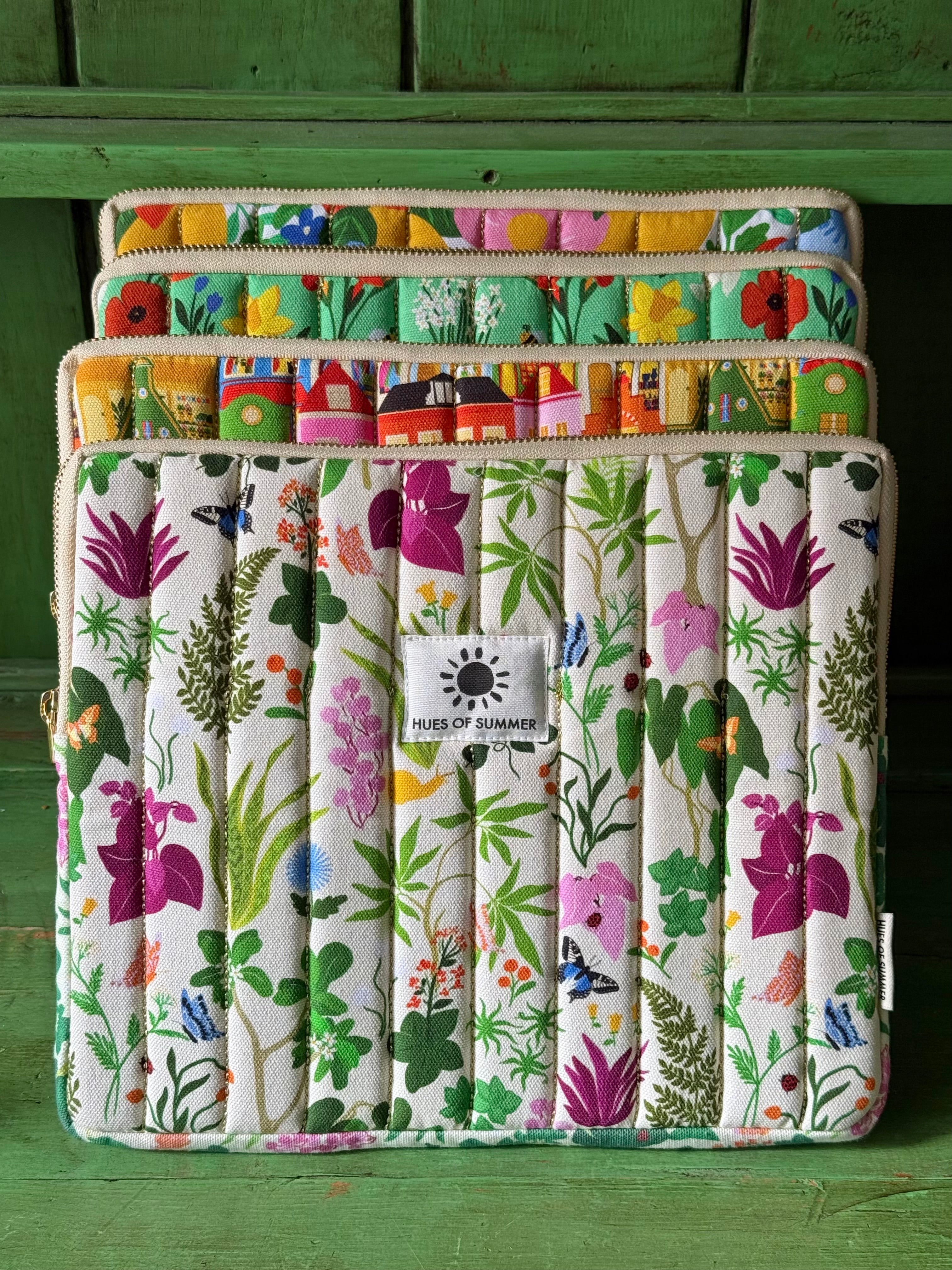 Ivory Bugs and Bloom tablet sleeve stacked with three other quilted sleeve designs