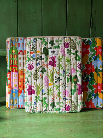 Bugs and Bloom quilted laptop sleeve displayed with an Amsterdam and a floral quilted sleeve