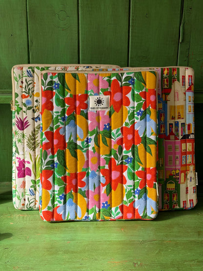 Citrus Bloom laptop sleeve displayed with a botanical and an Amsterdam quilted sleeve