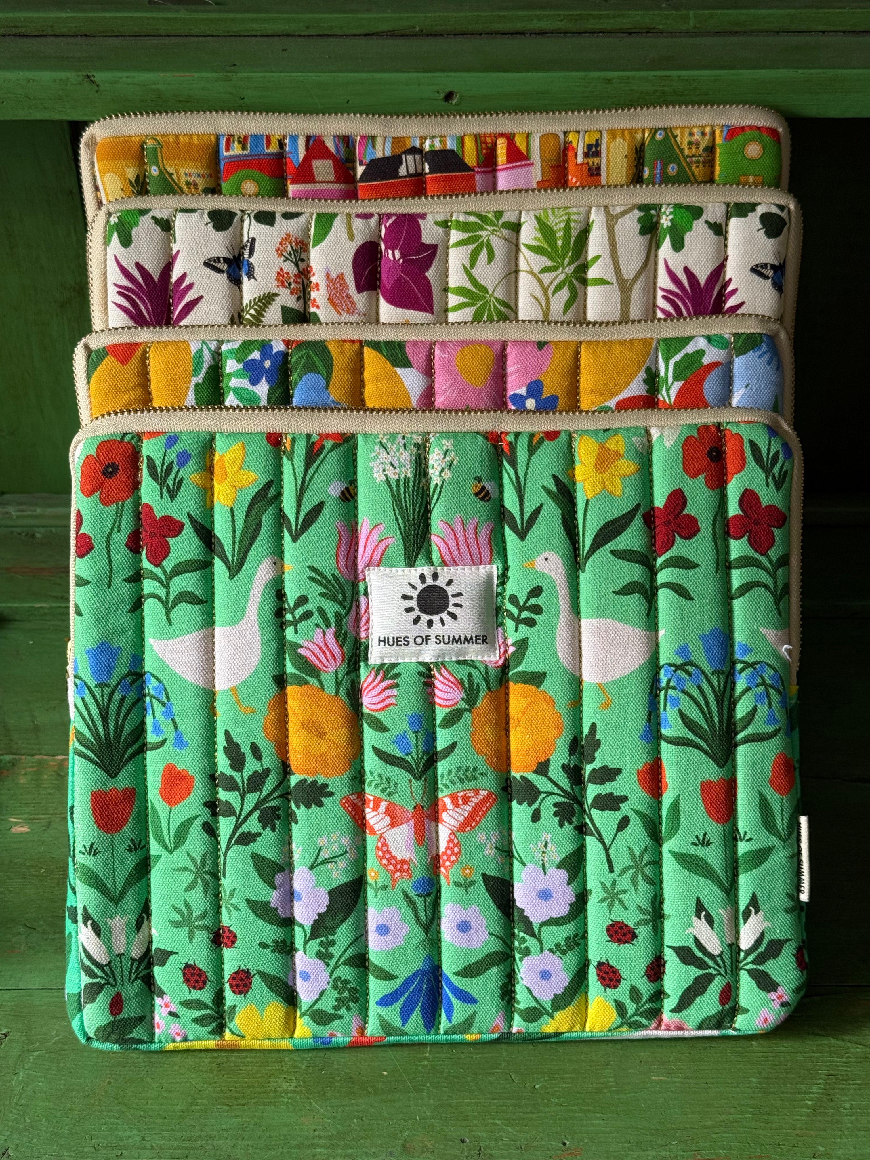 Garden Reverie tablet sleeve stacked with three other quilted sleeve designs