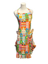 A colorful kitchen apron with a city building print, displayed on a white mannequin torso. The apron features multiple front pockets containing wooden utensils and is set against a dark blue paneled wall.