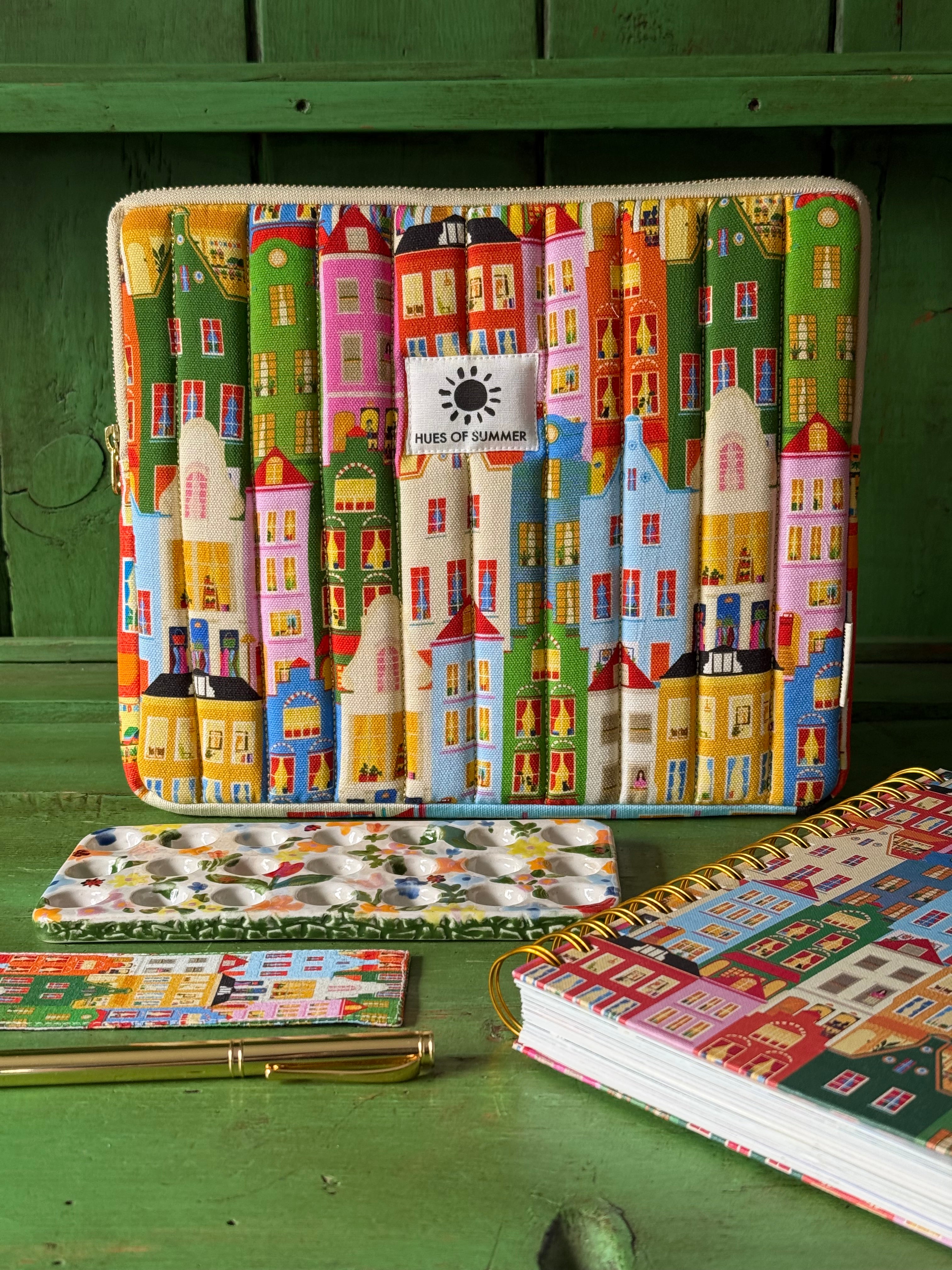 Amsterdam quilted tablet sleeve standing upright beside a matching notepad, coaster, and notebook